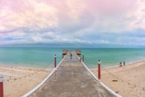 Pier in Sisal, Mexico over emerald waters
