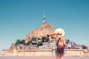 Rear view of woman looking at Le Mont Saint Michel- Normandie in France
