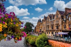 Victorian-era buildings line a busy street in Inverness, Scotland during summer